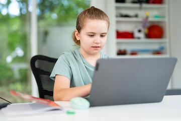 Kid reading books and writing homework in home school environment. Homeschool education helping children gain digital knowledge. Kid using laptop for interactive home school and knowledge growth.