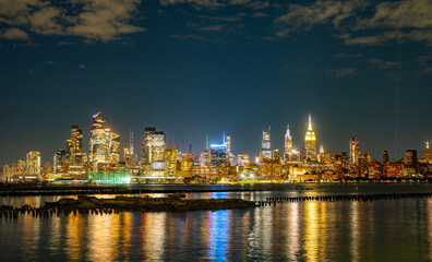 Fototapeta premium The Manhattan skyline in night New York city at dusk. Iconic city view of New York in night. NY night towers above the Hudson. NYC night skyscrapers against the sky. Famous New York panorama.