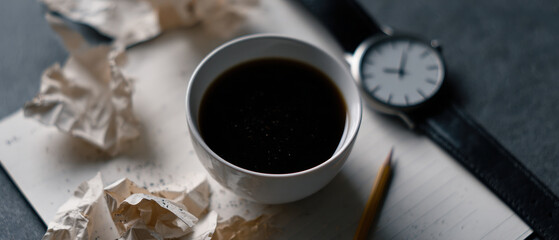 Dark coffee cup notebook pencil watch cluttered desk mood
