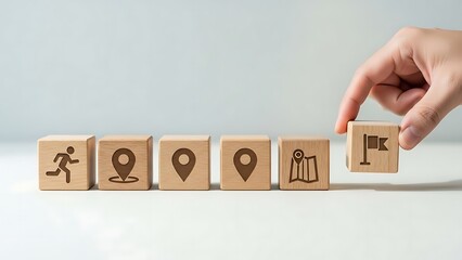 Wooden blocks illustrating journey from start to destination with hand placing flag