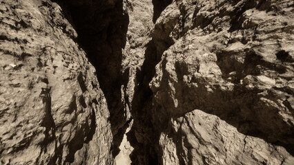 Sunlight filters into a narrow canyon, illuminating the rugged rock walls. The steep cliffs rise dramatically, creating a sense of adventure and mystery in this natural wonder.