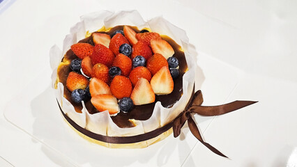 Strawberry and Blueberry Dessert Cake: A delectable dessert cheesecake crowned with fresh, vibrant strawberries and blueberries sits elegantly, promising a symphony of flavors and textures.