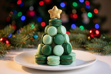 Christmas table setting with christmas tree made from macaroons green and mint colors on festive light background. Sweet dessert festive bakery