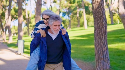 Playful senior couple having fun with a piggyback ride