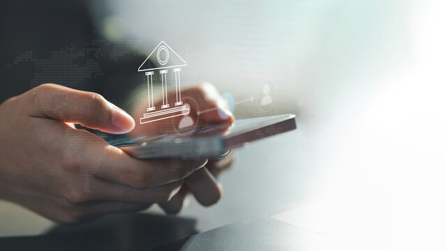 Close-up of hands using a smartphone with a digital banking icon, representing mobile payments, online transactions, secure fintech services, and modern financial technology.