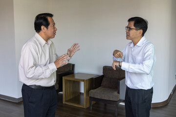 A businessman waiting for his colleague who is coming late. The man gets angry, blaming the unpunctual late comer