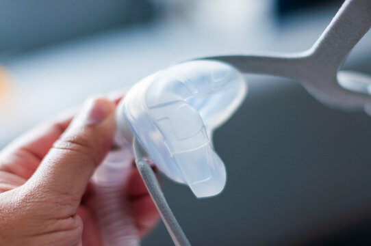 Adjusting a sleep apnea mask for better comfort home health care indoor close-up sleep quality