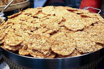 Stacked Nang Led (Thai Sweet Crispy Rice Cakes) with cane sugar drizzle. Authentic Thai street food dessert, featuring a rich puffed rice texture and caramel flavor. Ideal for Asian food concepts.