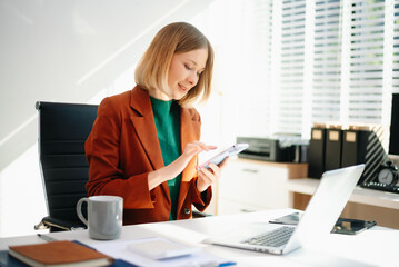 Business woman reviewing documents at desk in modern office. Ideal for finance, marketing, startup workflow, data analysis, productivity