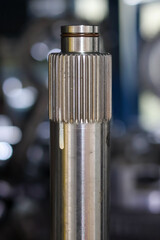 Close-up of a polished, cylindrical metal spline shaft featuring vertical grooves and an O-ring groove, highlighting precision engineering, power transmission, and automotive component quality.