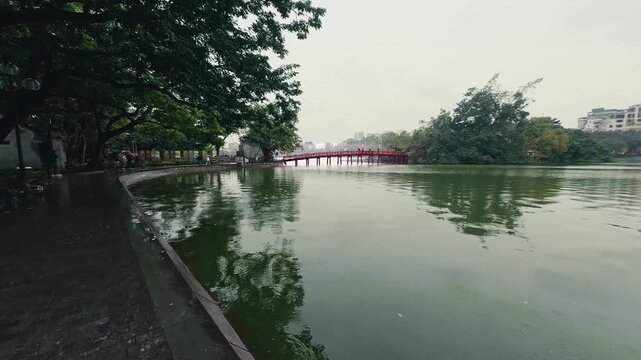 A peaceful rainy scene at Hoan Kiem Lake, featuring the iconic red bridge.