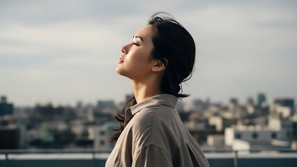 Serene young woman breathing fresh air on a city rooftop.