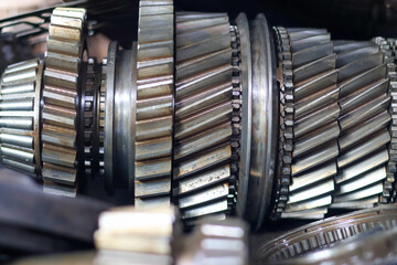 Close-up of a disassembled automotive transmission main shaft, featuring a series of stacked...