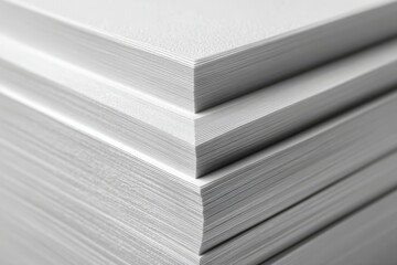 Neatly stacked white paper sheets with precisely aligned edges under dramatic directional light.