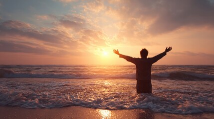 Young man arms outstretched by the sea at sunrise enjoying freedom and life, people travel wellbeing concept