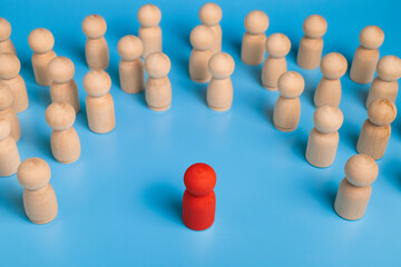 Obraz premium red wooden figure stand to the wooden group crowd. isolated on blue background. leadership and teamwork concept