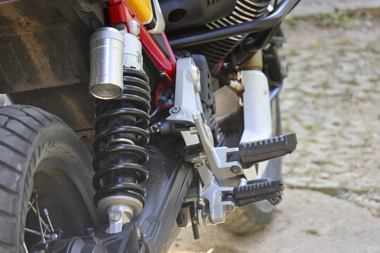 Detailed close up view of custom motorcycle rear wheel and suspension. shock absorber, tire, and mechanical part highlight powerful engineering of machine