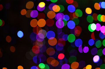 Colorful bokeh light effect on dark background creating a fun and festive atmosphere, perfect for party or holiday themes