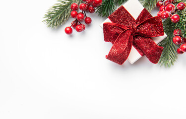 Christmas giftbox with red ribbon and holly berries