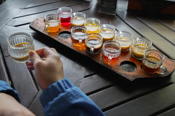 A collection of drinks in cups is served on the table as a means for guests to sample before ordering.