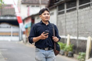 Man walking in an alley while using smartphone