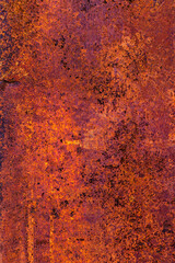 Metal surface with a thick layer of rust, exhibiting a predominantly purple hue with hints of orange and a rough texture