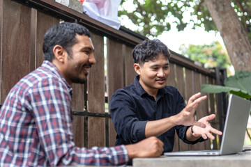 Two men working together in an outdoor cafe space