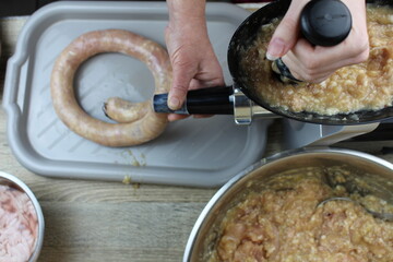 We fill homemade chicken sausages with meat in our own kitchen.