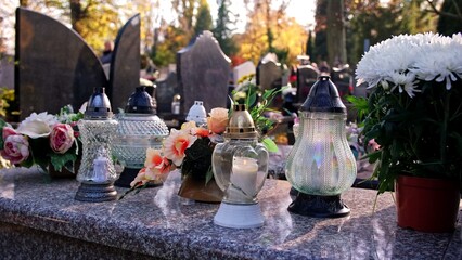 Votive Candle Lanterns on Limestone Grave Tombstone Surface at City Cemetery on All Saint Day