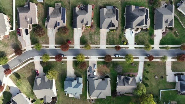 Colored trees along road of luxury neighborhood with villas and mansion. Aerial top down shot. Peaceful suburb residential area in America at fall season. Large property and real estates.