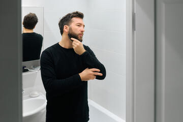 Man grooming himself in a modern bathroom during morning routine