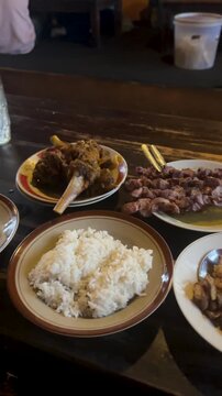 Diners savoring delicious Sate Klatak and traditional Indonesian dishes at a Yogyakarta restaurant
