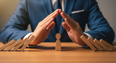 Businessman in suit protects wooden figure with hands, surrounded by falling blocks, symbolizing risk management and support in challenging situations