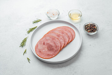 Sliced sausage on white plate with herbs and spices