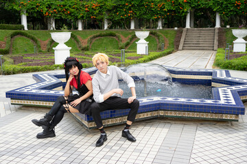 Cosplayers relaxing on a star-shaped fountain in a park