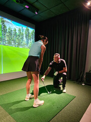 Golf training session at an indoor simulator with a coach