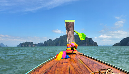 Longtail boat navigating Phangnga Bay's limestone islands, Takua Thung, Thailand.