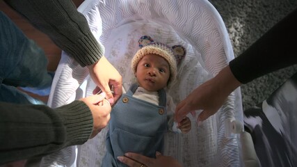 Adorable newborn Baby rests in a cozy bassinet as caring parents gently adjust clothing creating a warm tender family moment with soft natural light and a calm comfortable home atmosphere