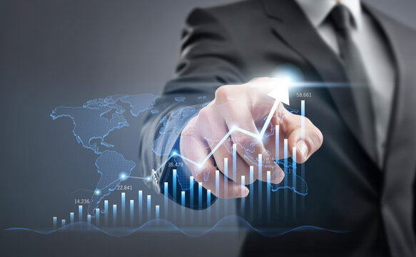 Businessman hand pointing at a futuristic digital interface with a bar chart showing financial growth, stock market success, and business progress.