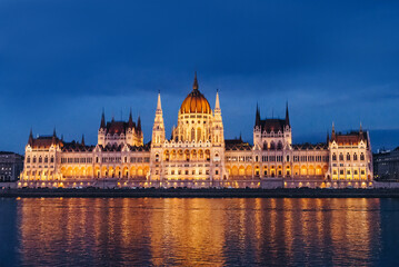 Fototapeta premium Illuminated Hungarian Parliament Building at night reflecting in the Danube River.