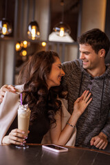 Young couple enjoying their time together in a café, laughing