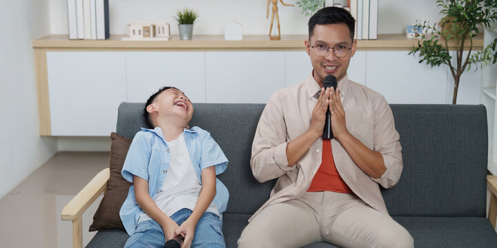 Family Life: Father and son enjoying karaoke session at home