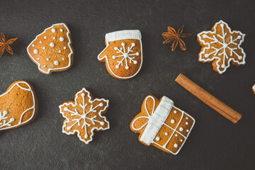 Sweet Christmas cookies shaped like trees mittens snowflakes and gifts with cinnamon sticks