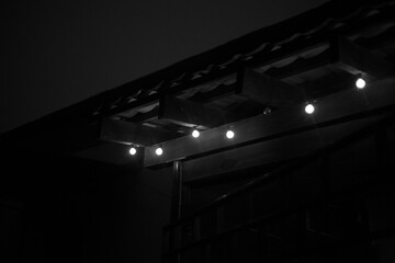 Nighttime scene with illuminated lights under a roof.