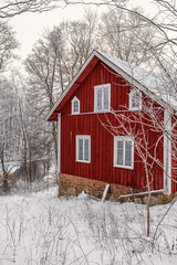 Red wooden house in a forest a cold frosty winter day © Lars Johansson