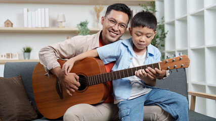 Family Life: Father and son enjoying music together with a guitar