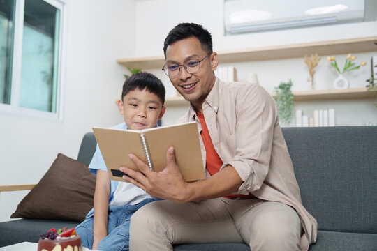 Family Life: Father reading a book with his son at home