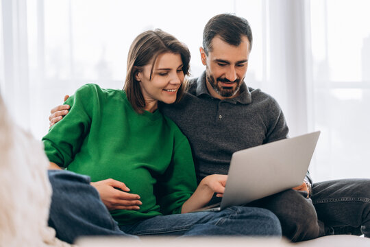 Pregnant couple shopping online for baby products - Powered by Adobe