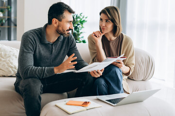 Couple discussing home finances, planning family budget © Maria Vitkovska