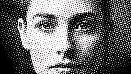 Close-up Black and White Portrait of a Young Woman with Striking Eyes and Subtle Shadowing